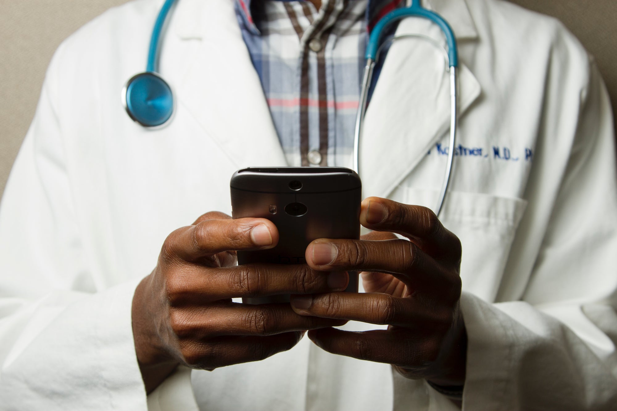 A closeup of a doctor on their smartphone representing a doctor on call and giving instructions over the phone