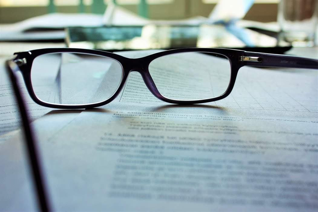 a pair of glasses sitting on top of a document